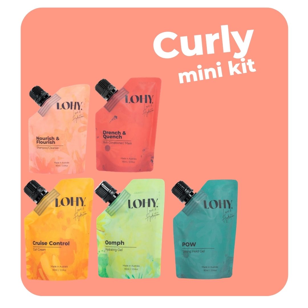 lohy. curly hair mini kit, which includes mini shampoo, mini rich conditioner, mini curl cream, mini hydrating gel and mini strong hold gel pouches on a pastel peach background