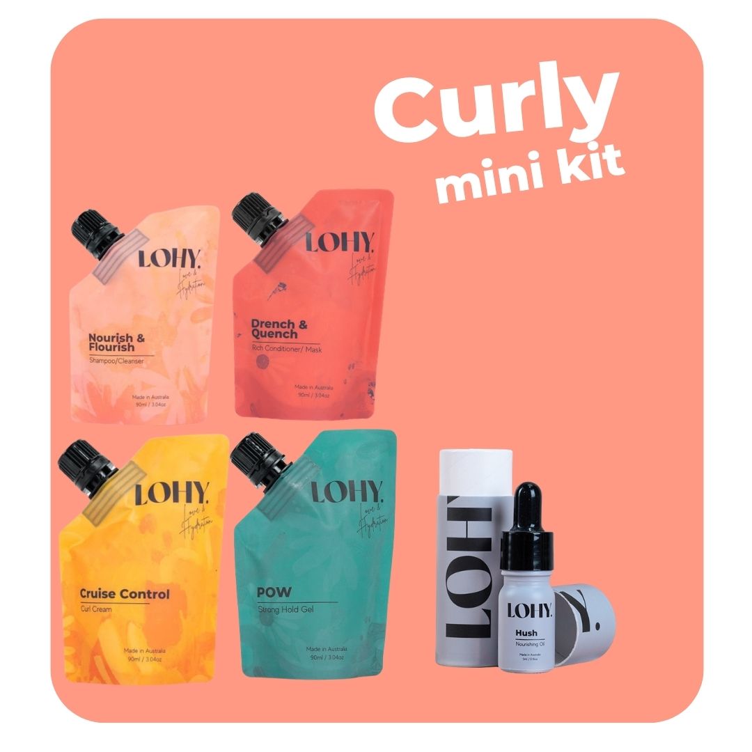 lohy. curly hair kit, which includes mini shampoo, mini rich conditioner, mini curl cream, and mini strong hold gel pouches, and mini nourishing oil bottle on a pastel peach background