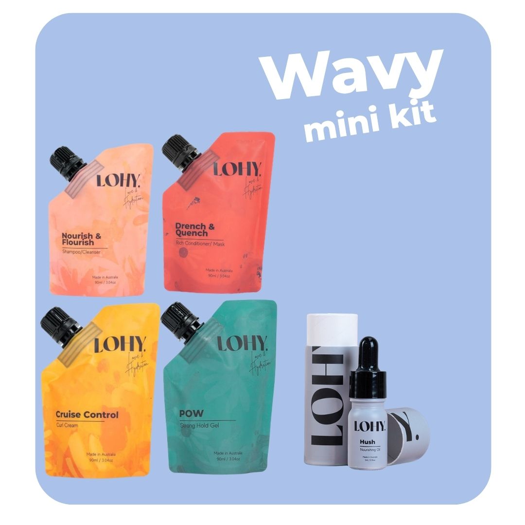 lohy. curly hair mini kit, which includes mini shampoo, mini rich conditioner, mini curl cream, mini strong hold gel pouches, and a mini hush bottle on a pastel blue background