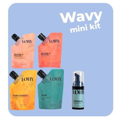 lohy. wavy hair mini kit, which includes mini shampoo, mini conditioner, mini curl cream, mini strong hold gel pouches, and a mini volumising foam bottle on a pastel blue background