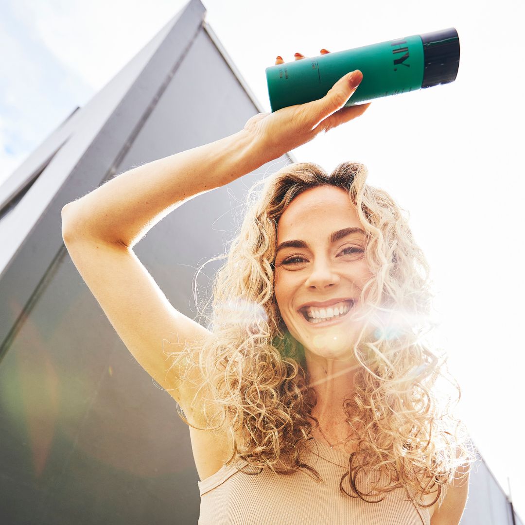 Person with blonde curls posing in the sunlight