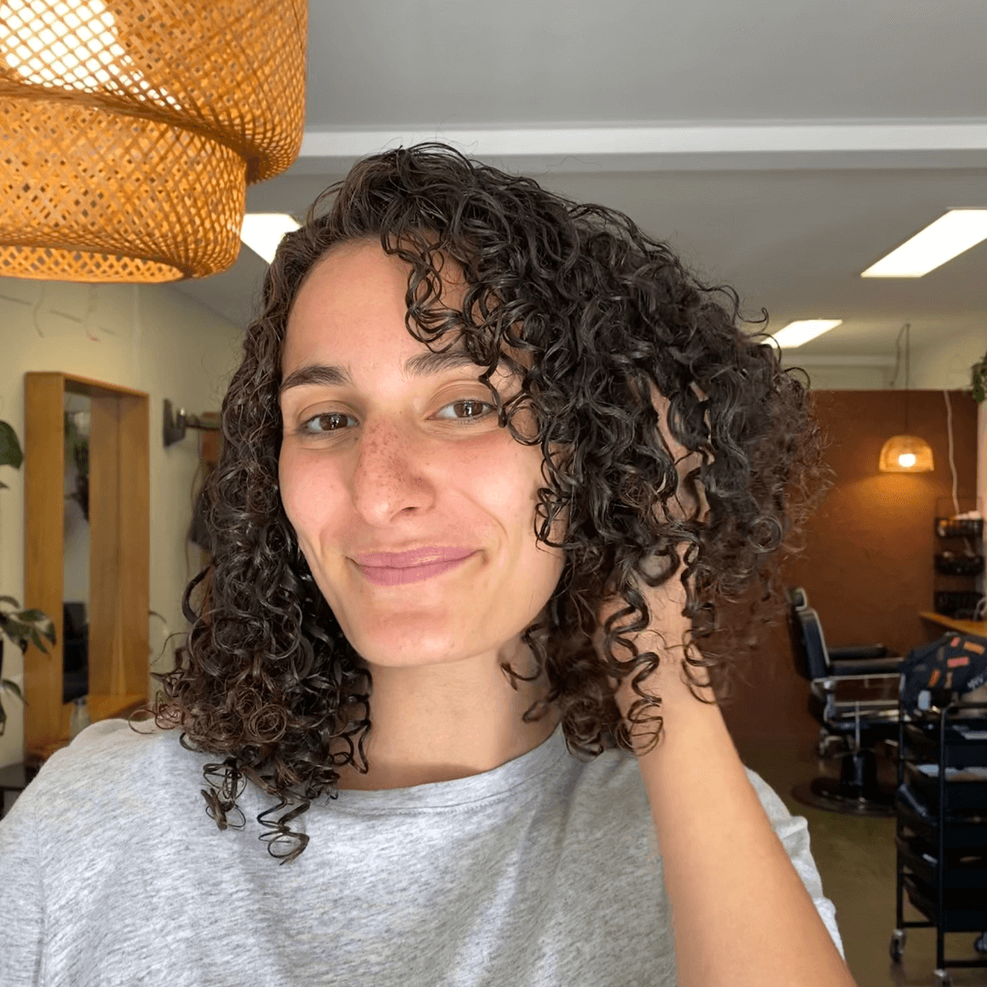 woman scrunching bob cut curly brunette hair