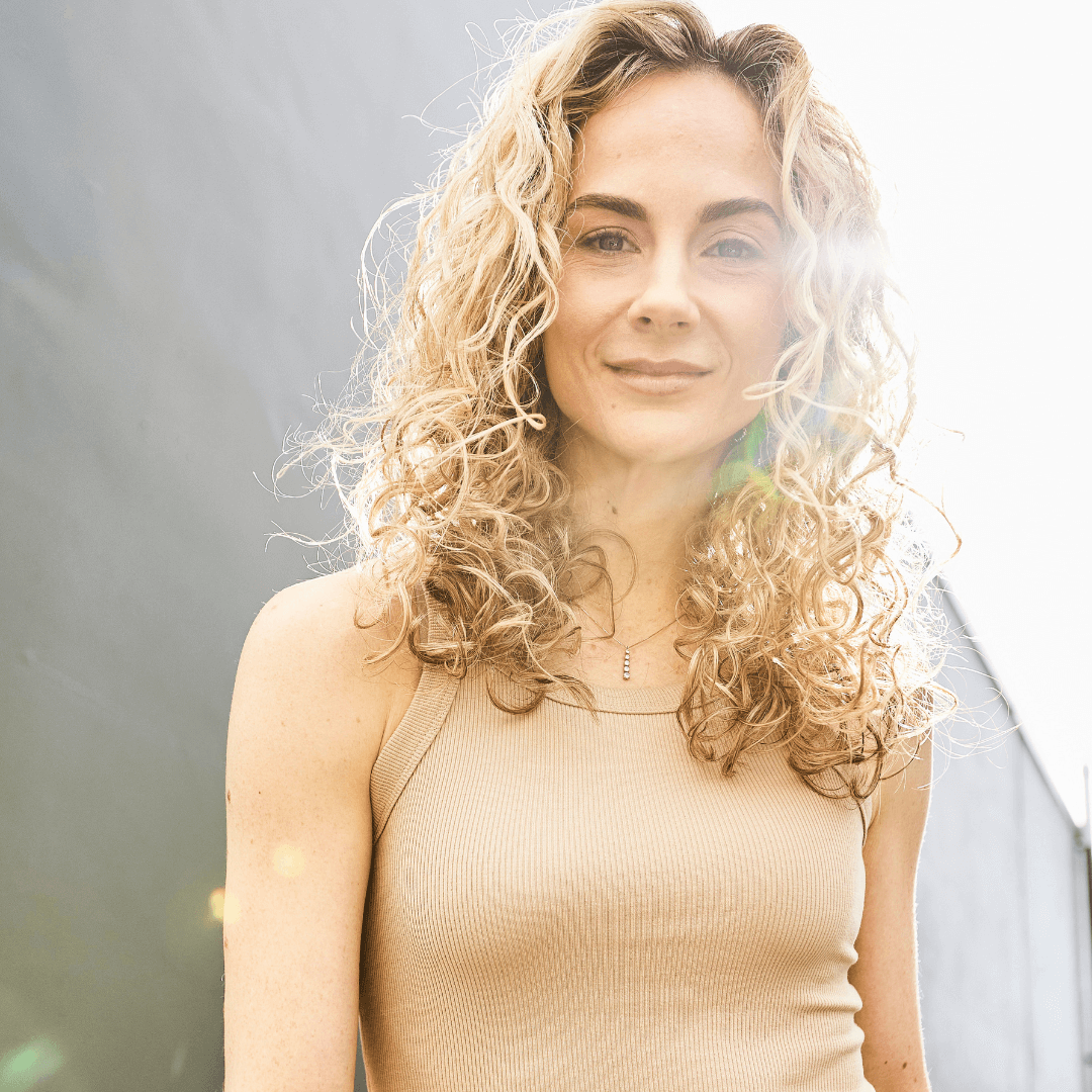 woman in sun with shoulder length curly blonde hair