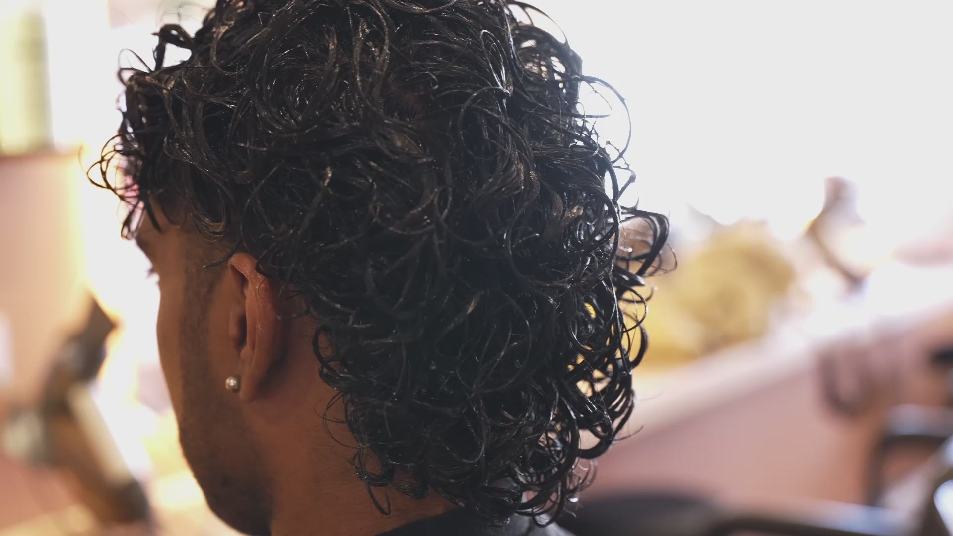 Load video: Lady using moisturising hair product for curly hair