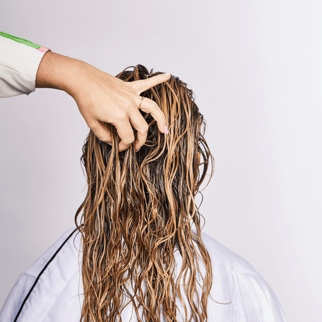 woman pinching long curly blonde hair