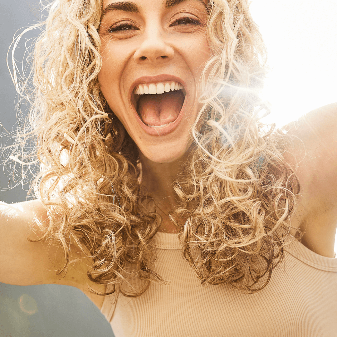 happy girl with shoulder length curly blonde hair